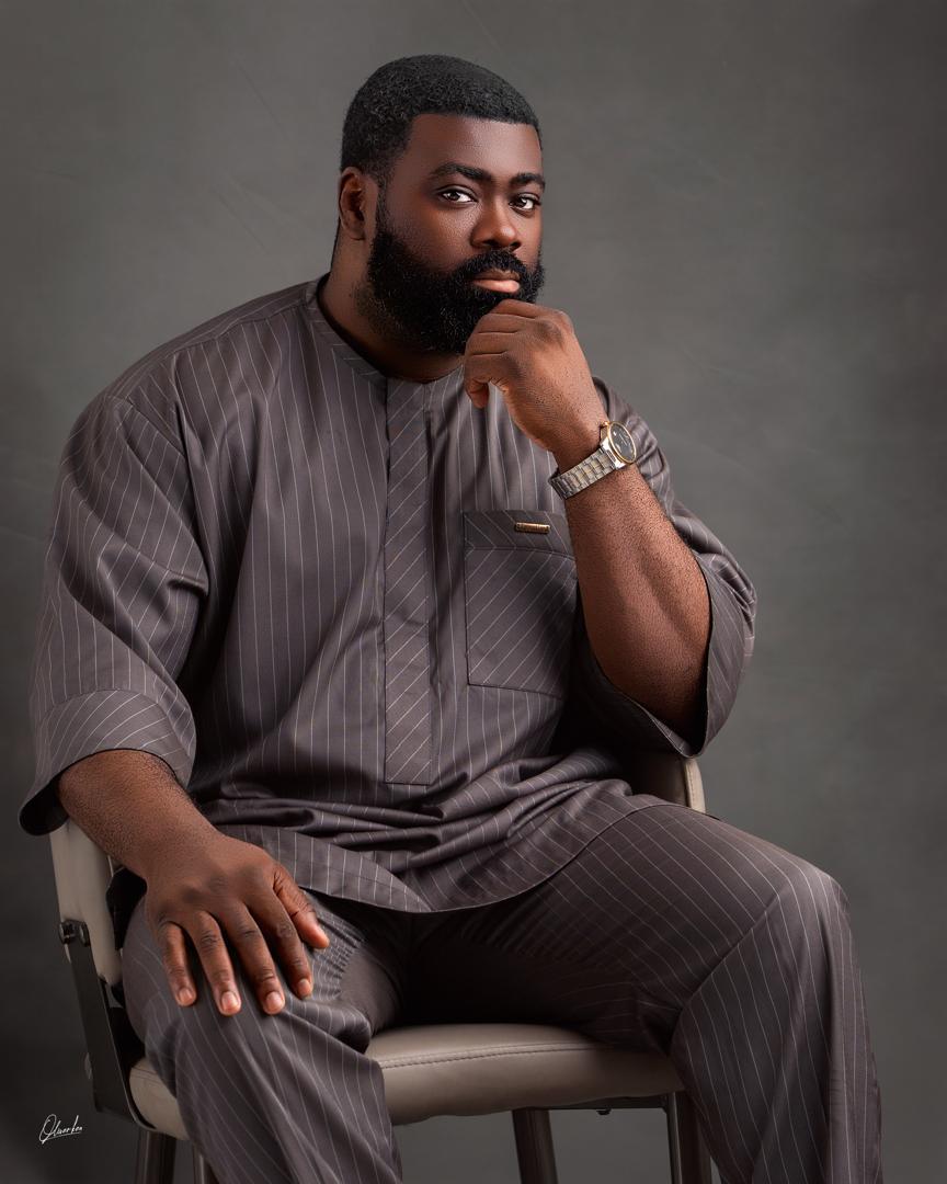 Deji Whesu seated in a grey traditional outfit